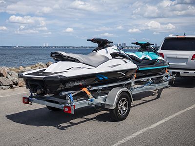 Jet skis on a trailer near the water