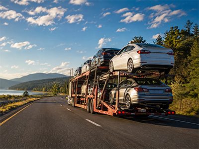 Car carrier on a scenic highway in early morning light